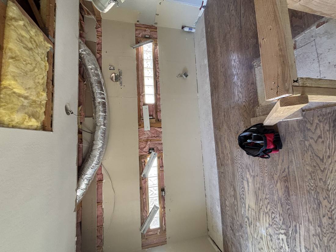 Ceiling and wall demolition exposing insulation and framing